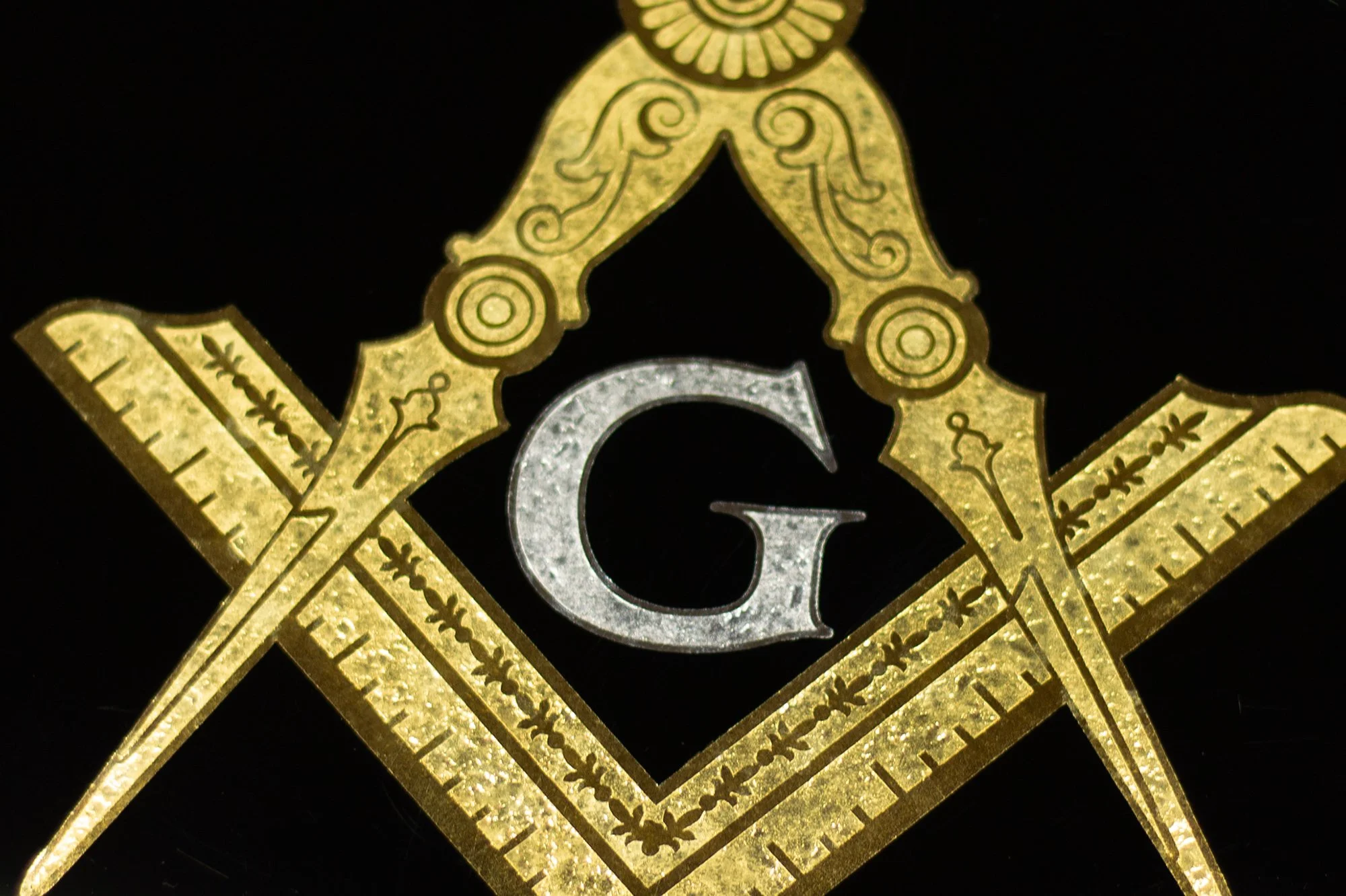 Close-up of the letter G inside the Masonic square and compasses